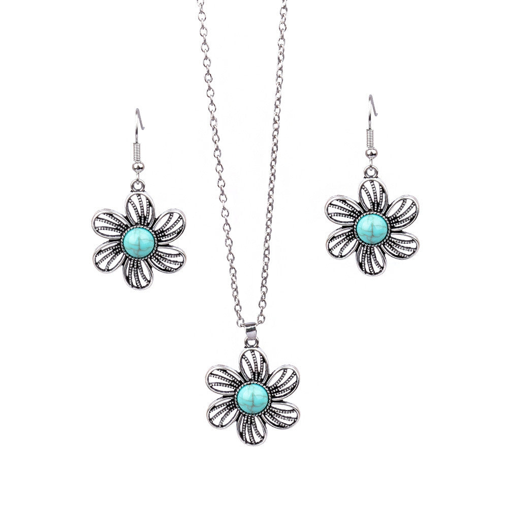 Jewelry set with flower-shaped earrings and pendant on a white background