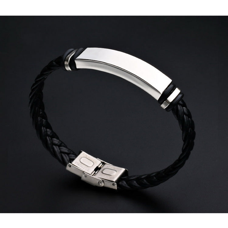 Black braided leather bracelet with silver metal clasp on a dark background