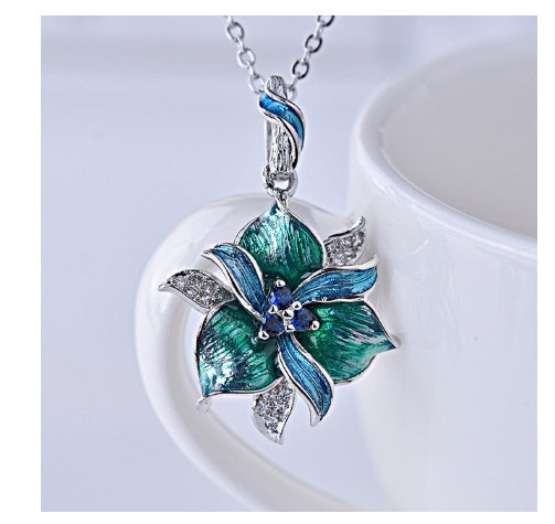 Blue and green floral pendant necklace on a white background