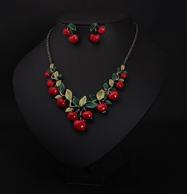 Jewelry set with red berry design on a black background