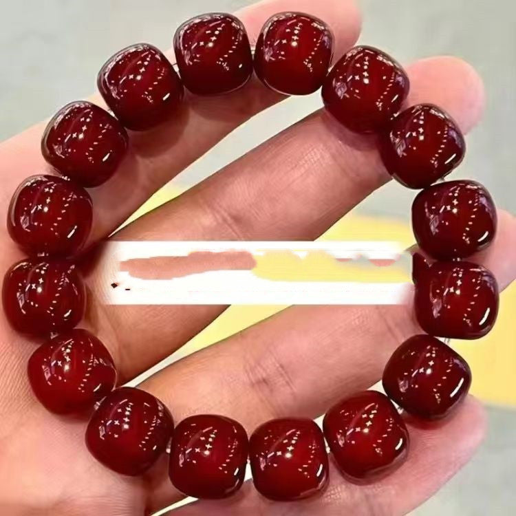 Red beaded bracelet on a hand with a blurred background