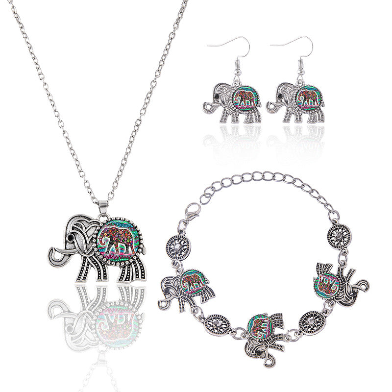 Jewelry set with elephant-themed necklace, bracelet, and earrings on a white background