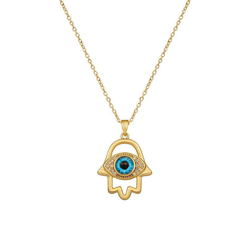 Gold necklace with a Hamsa hand pendant featuring a blue eye on a white background