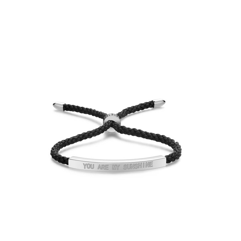 Black braided bracelet with silver tag on a white background