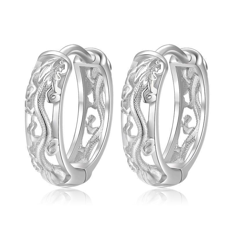 Pair of silver hoop earrings with intricate designs on a white background