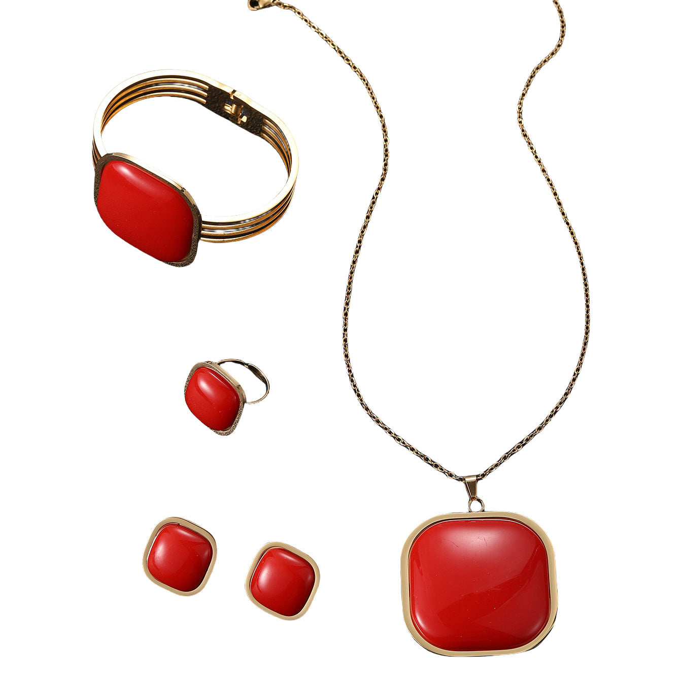Jewelry set with red stones and gold accents on a white background