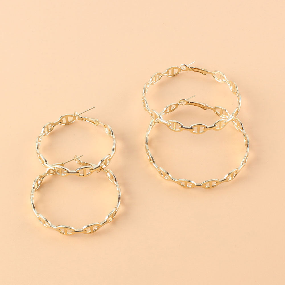 Gold hoop earrings on a beige background
