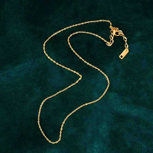 Gold chain necklace on a dark green textured background