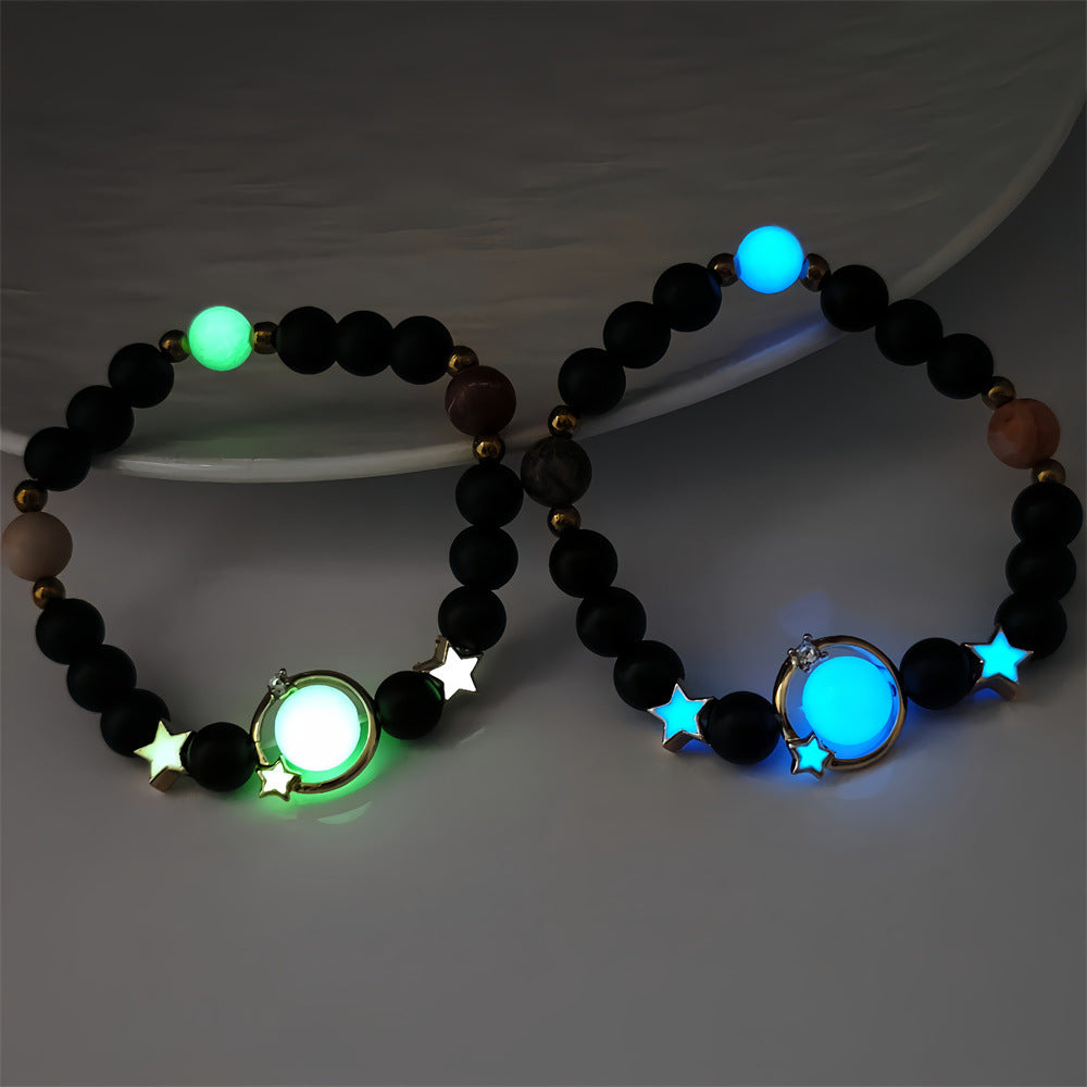 Two beaded bracelets with glowing green and blue elements on a dark background