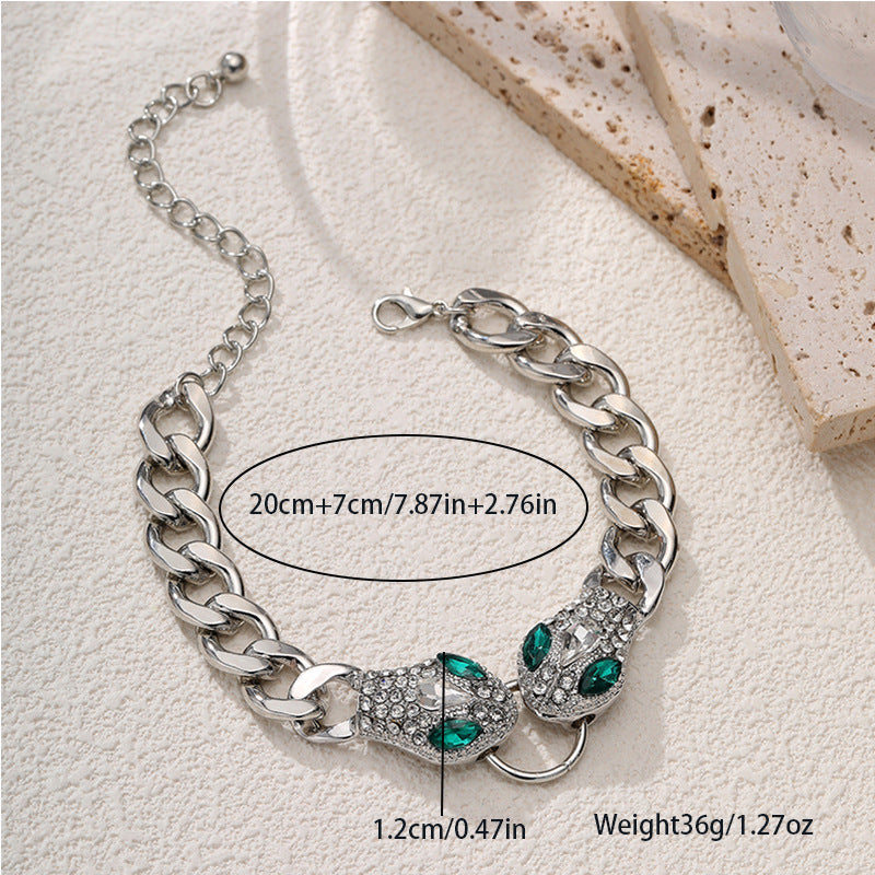 Silver chain bracelet with green gemstones on a light background