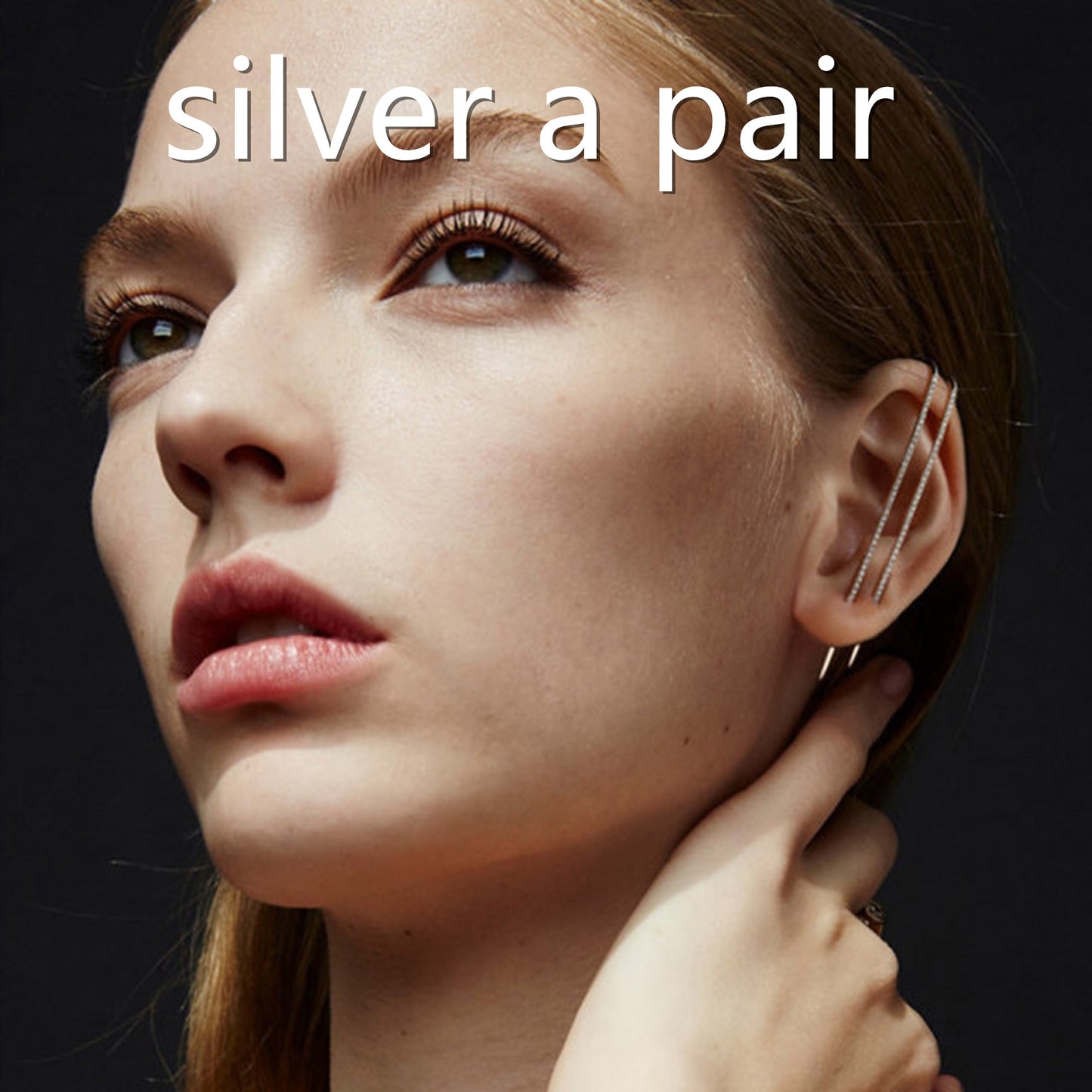 Close-up of a woman wearing silver earrings with text 'silver a pair' on a dark background