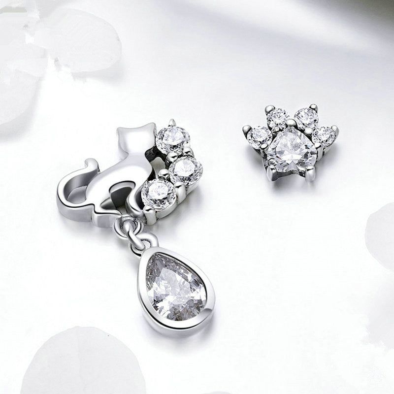 Silver jewelry set with teardrop pendant and circular earrings on a white background