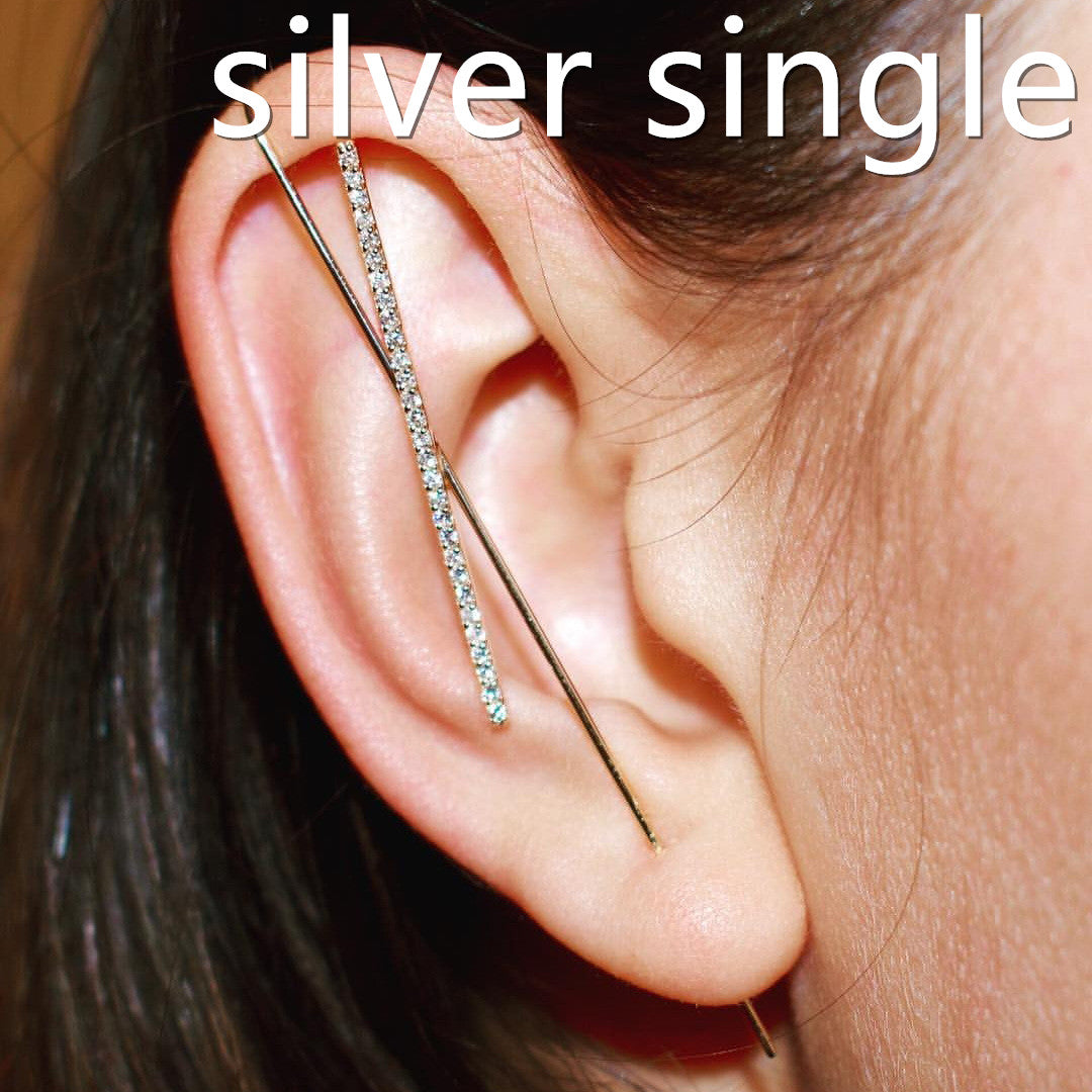 Close-up of an ear with a silver single earring.