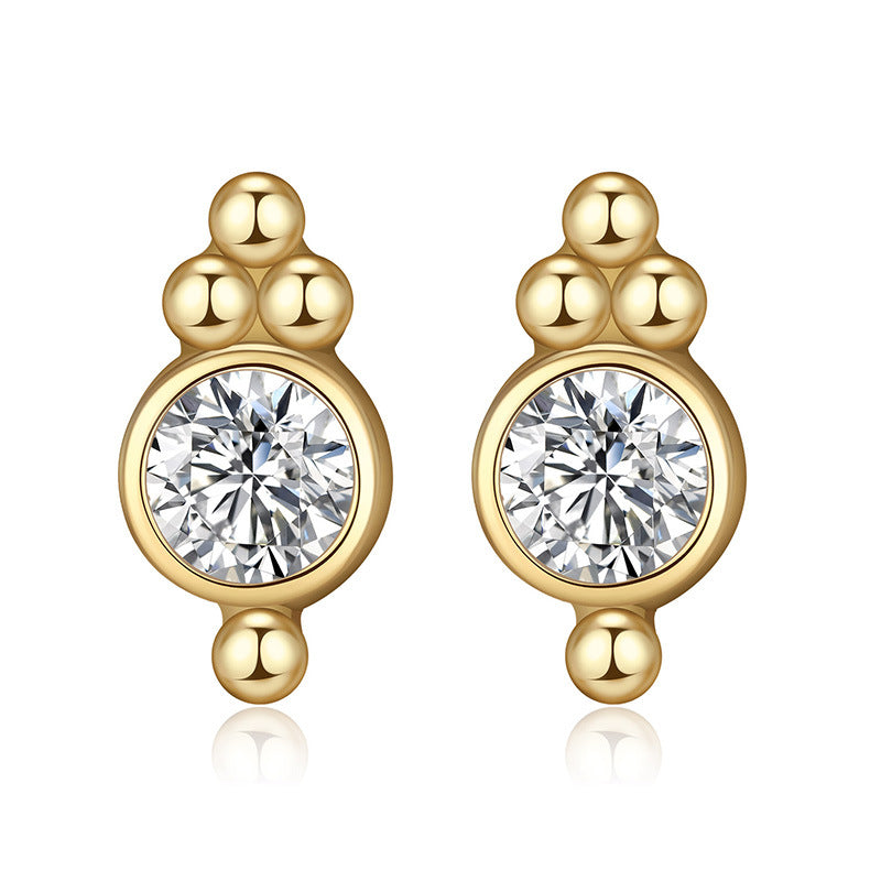 Gold earrings with round gemstones on a white background