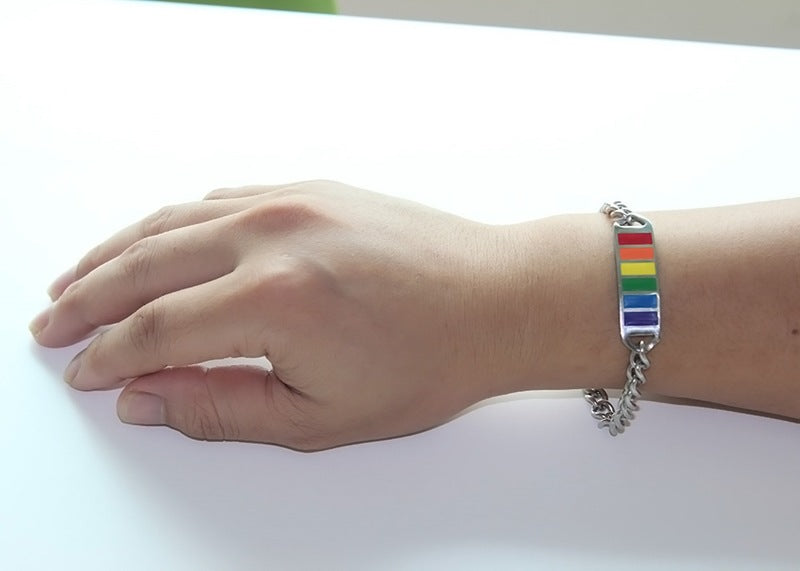 Hand wearing a rainbow bracelet on a white background