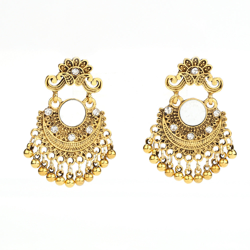 Pair of gold earrings with intricate designs on a white background