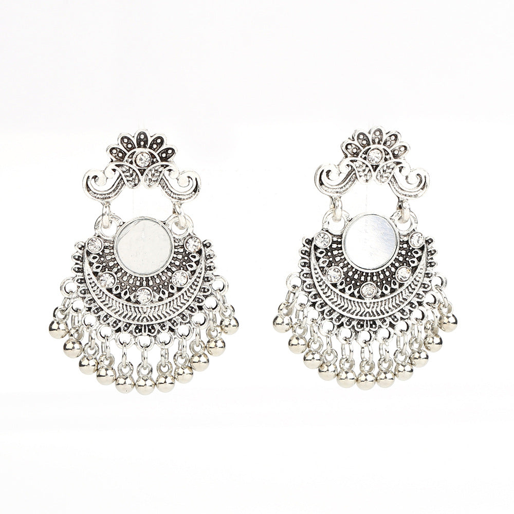Pair of silver earrings with intricate designs on a white background