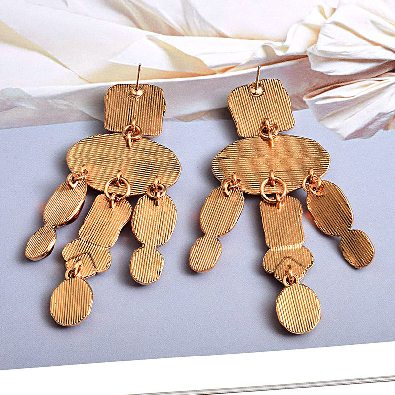 Pair of gold chandelier earrings on a light background