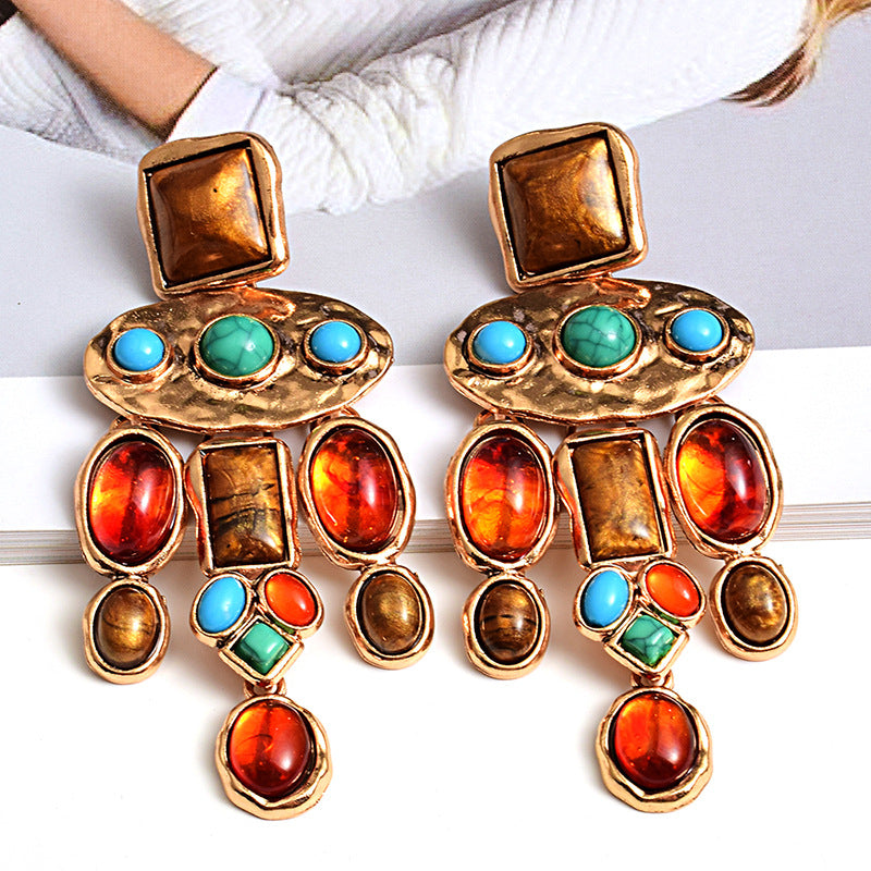 Colorful earrings with gold accents on a white background