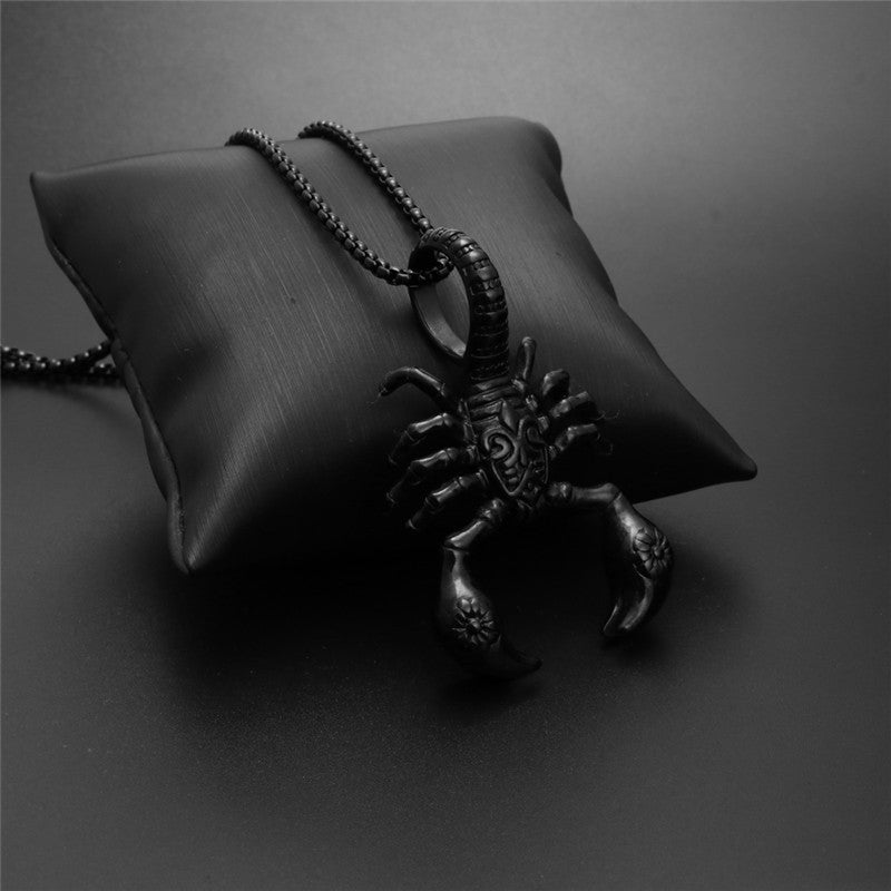 Black scorpion pendant on a dark surface