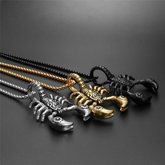 Three scorpion-shaped pendants on chains against a dark background