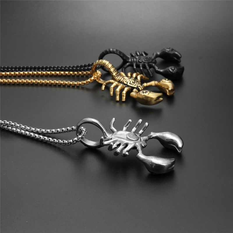 Three scorpion-shaped pendants on chains against a dark background