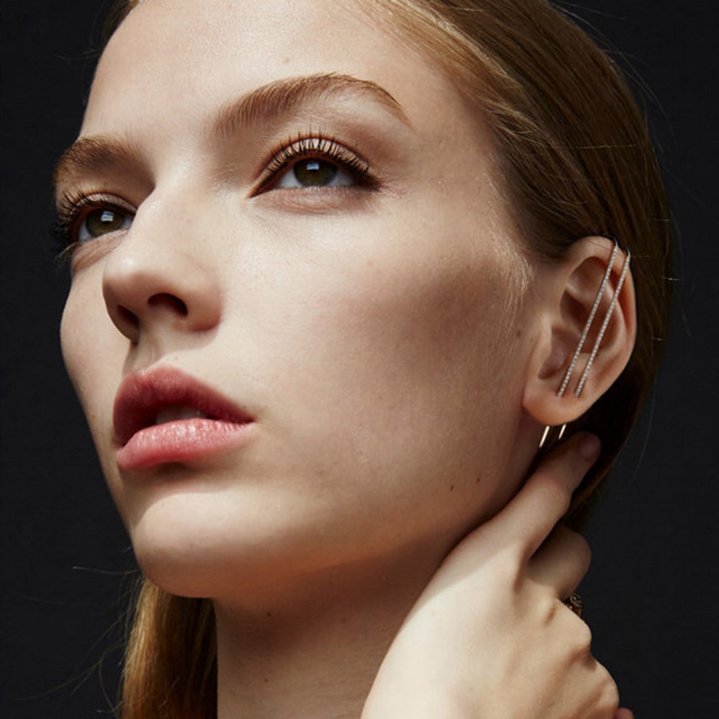 Close-up of a woman wearing an earring with a dark background