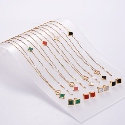 Gold necklaces with various colored pendants on a white background