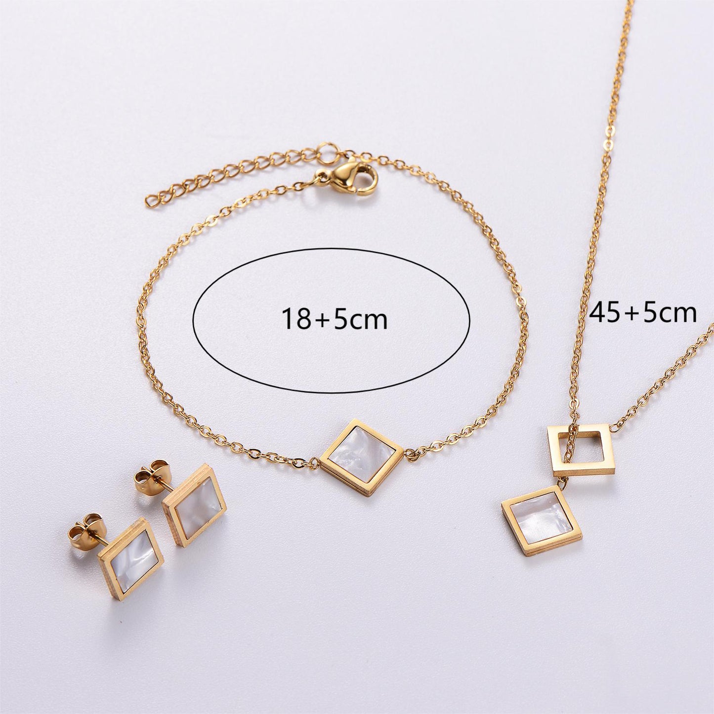 Gold jewelry set with necklace and earrings on a light gray background