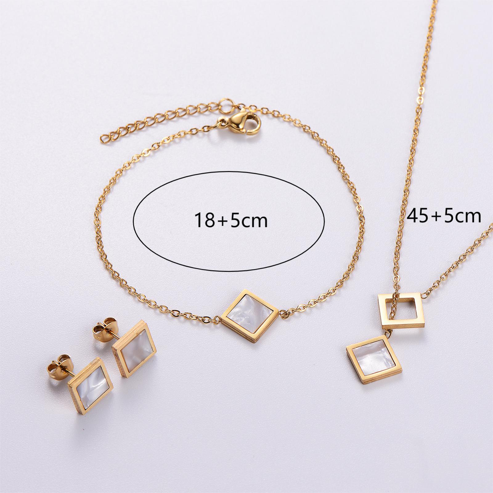 Gold jewelry set with necklace and earrings on a light gray background