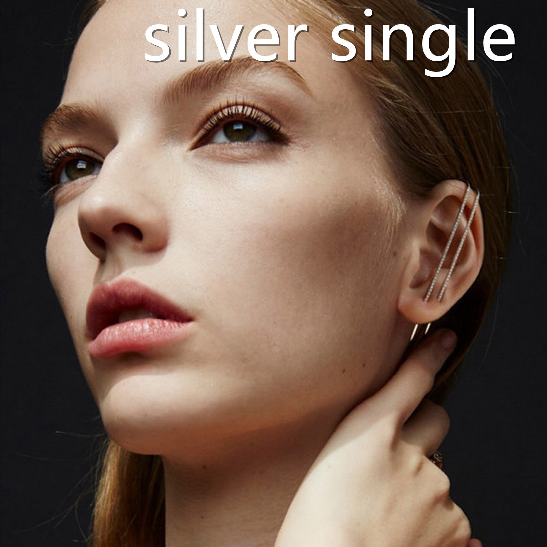 Close-up of a woman wearing a silver earring with the text 'silver single' above her.