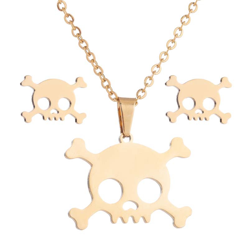 Gold skull necklace and earrings on a white background