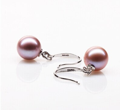 Pair of pink pearl earrings on a white background