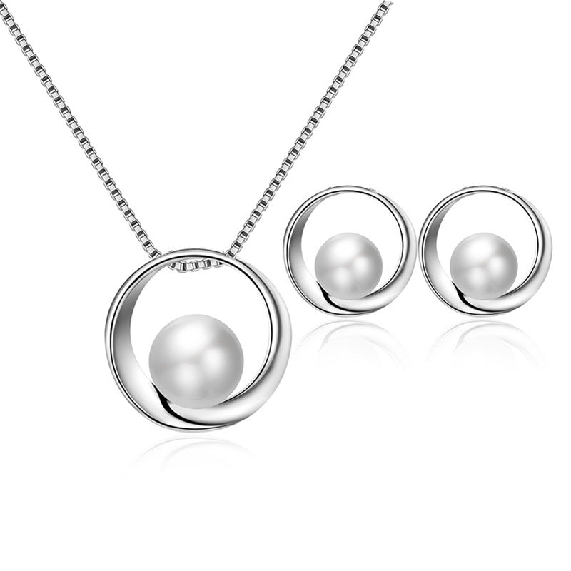 Pearl necklace and earrings set on a white background