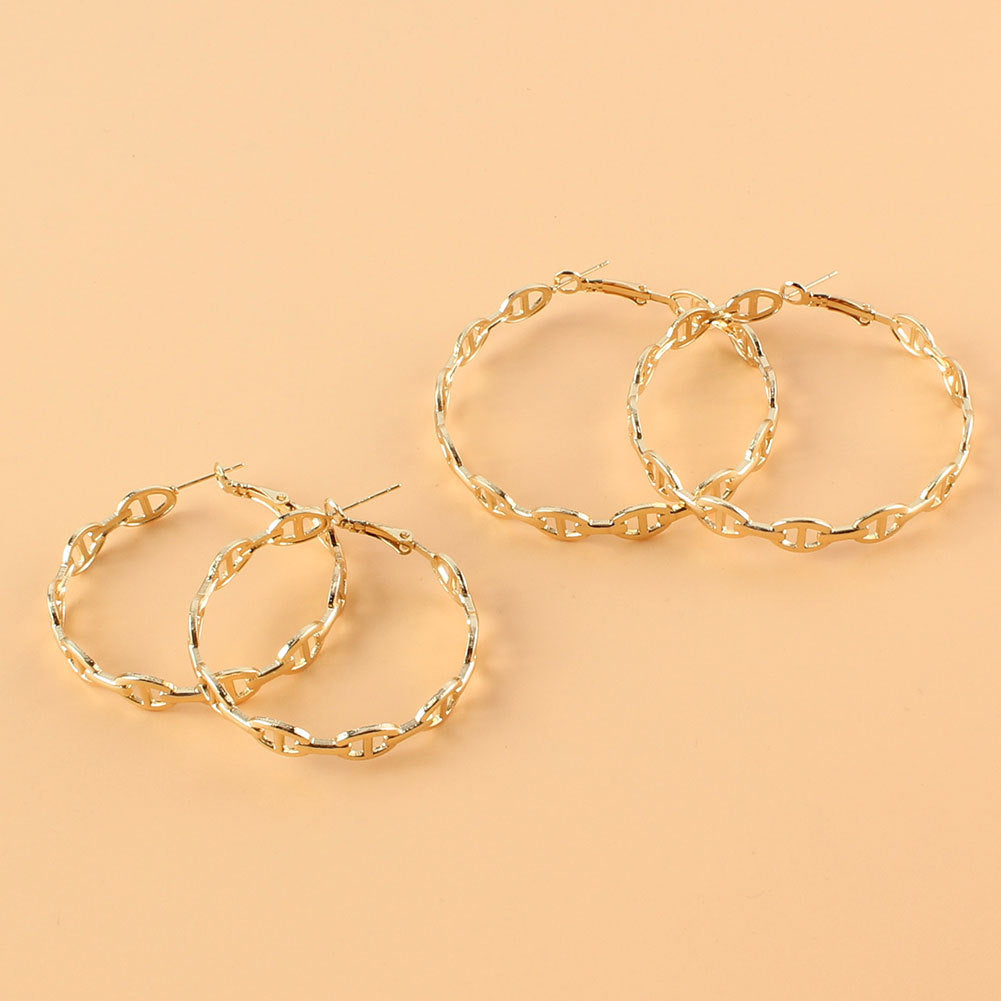 Gold hoop earrings on a beige background
