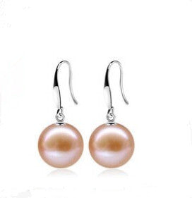 Pair of pink pearl earrings on a white background