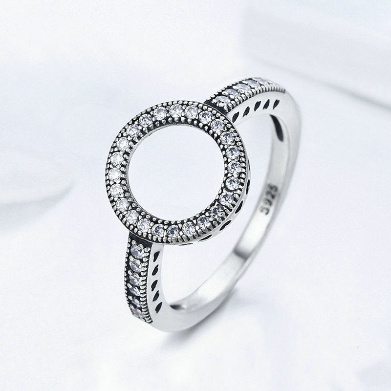 Silver ring with diamond accents on a white background
