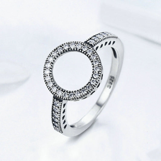Silver ring with diamond accents on a white background