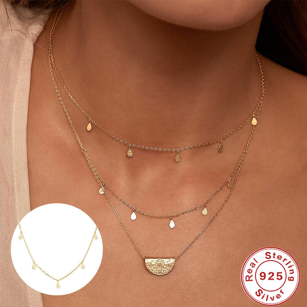 Gold necklace with a close-up inset and 'Real Sterling 925' stamp on a dark background