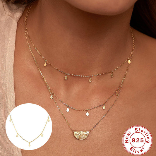 Gold necklace with a close-up inset and 'Real Sterling 925' stamp on a dark background