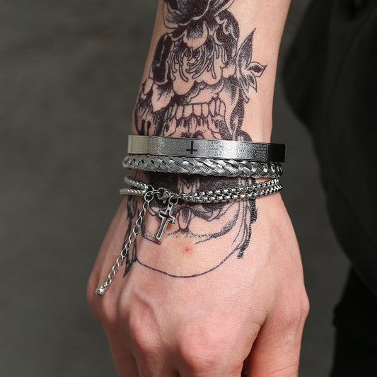 Hand wearing multiple bracelets with tattoos on the arm