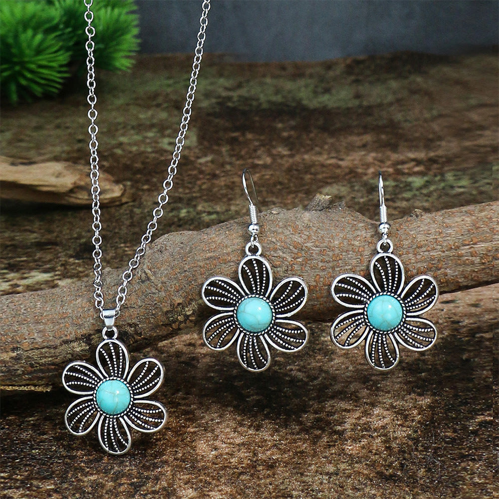 Floral jewelry set with turquoise stones on a wooden surface