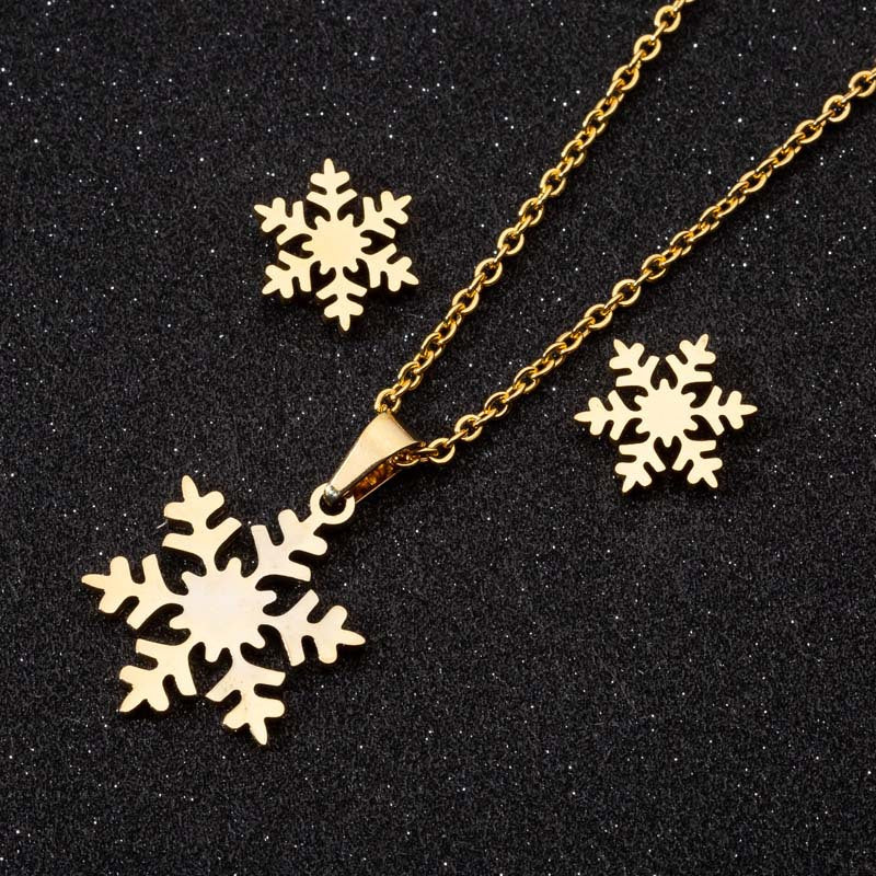 Gold snowflake necklace and earrings on a black background