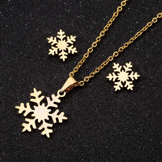 Gold snowflake necklace and earrings on a black background
