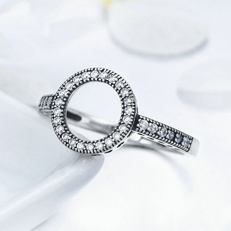Silver ring with embedded diamonds on a white background