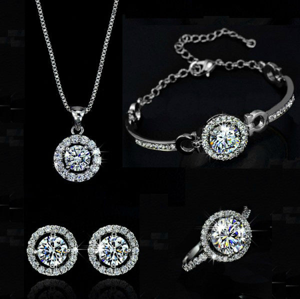 Jewelry set with necklace, bracelet, ring, and earrings featuring round gemstones on a black background.