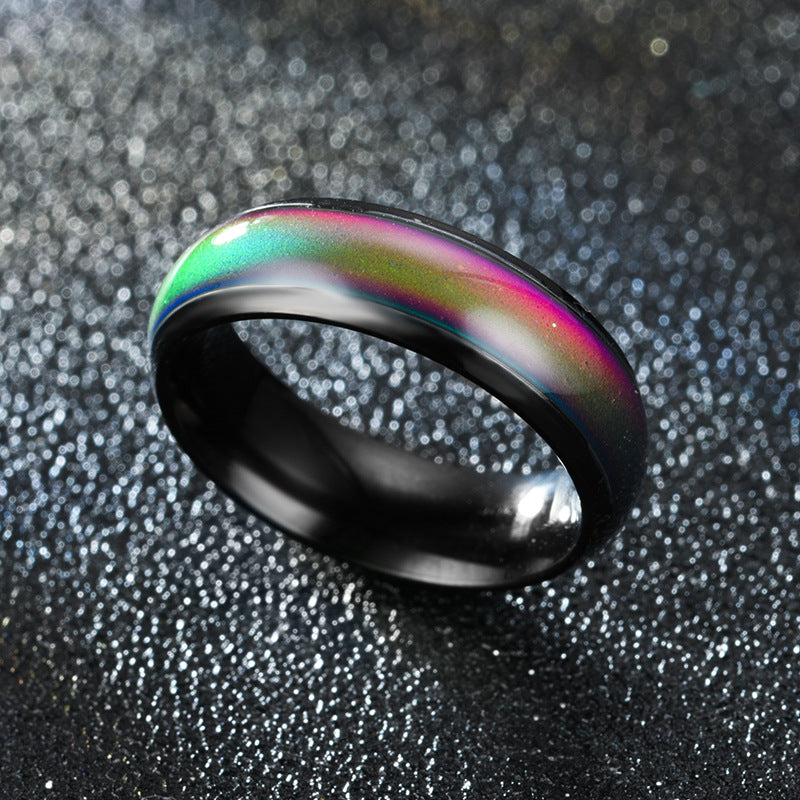 Ring with black band and colorful interior on a textured gray background
