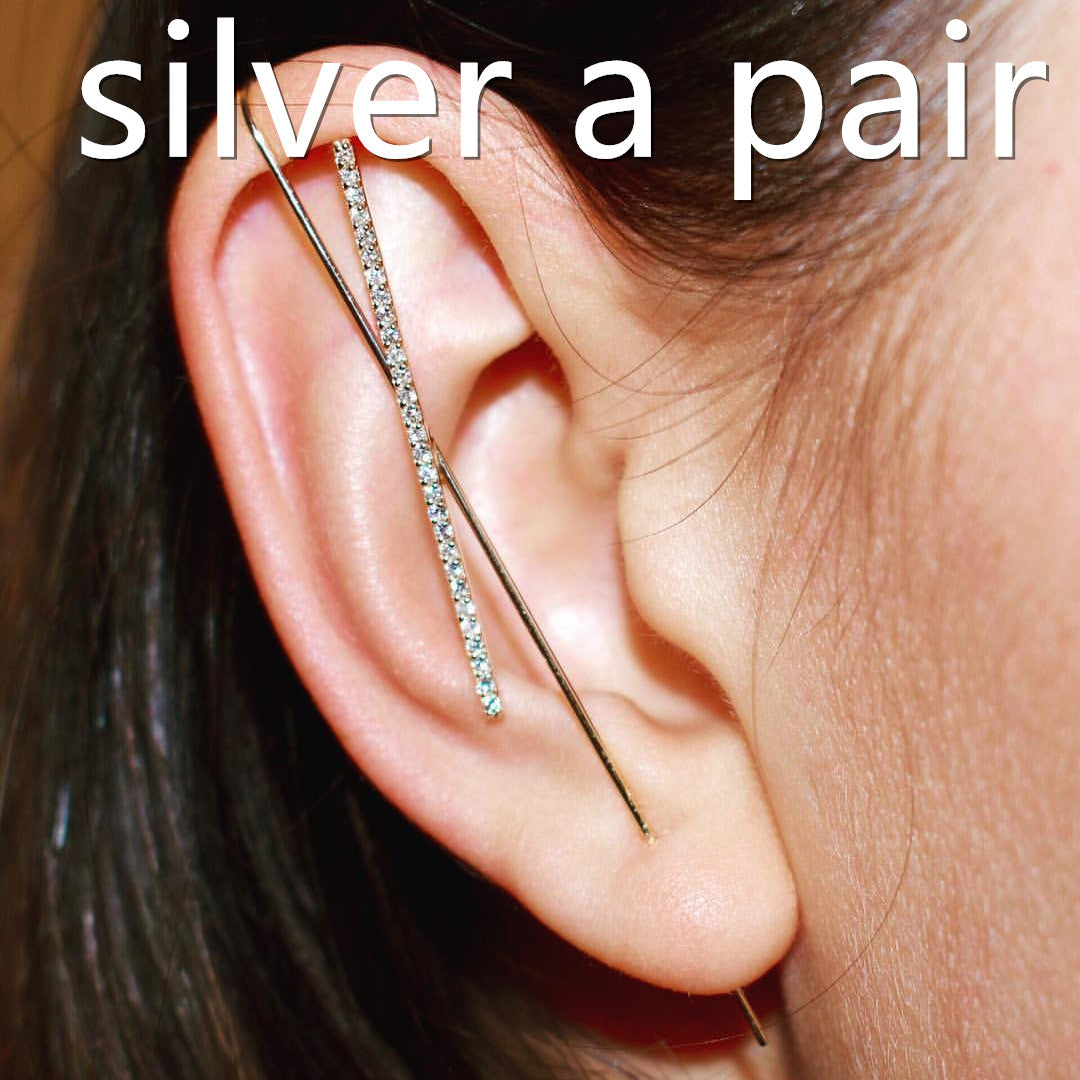 Close-up of an ear wearing a silver earring with text 'silver a pair' above.
