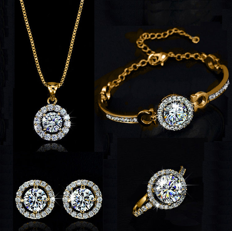 Gold jewelry set with necklace, bracelet, earrings, and ring on a black background