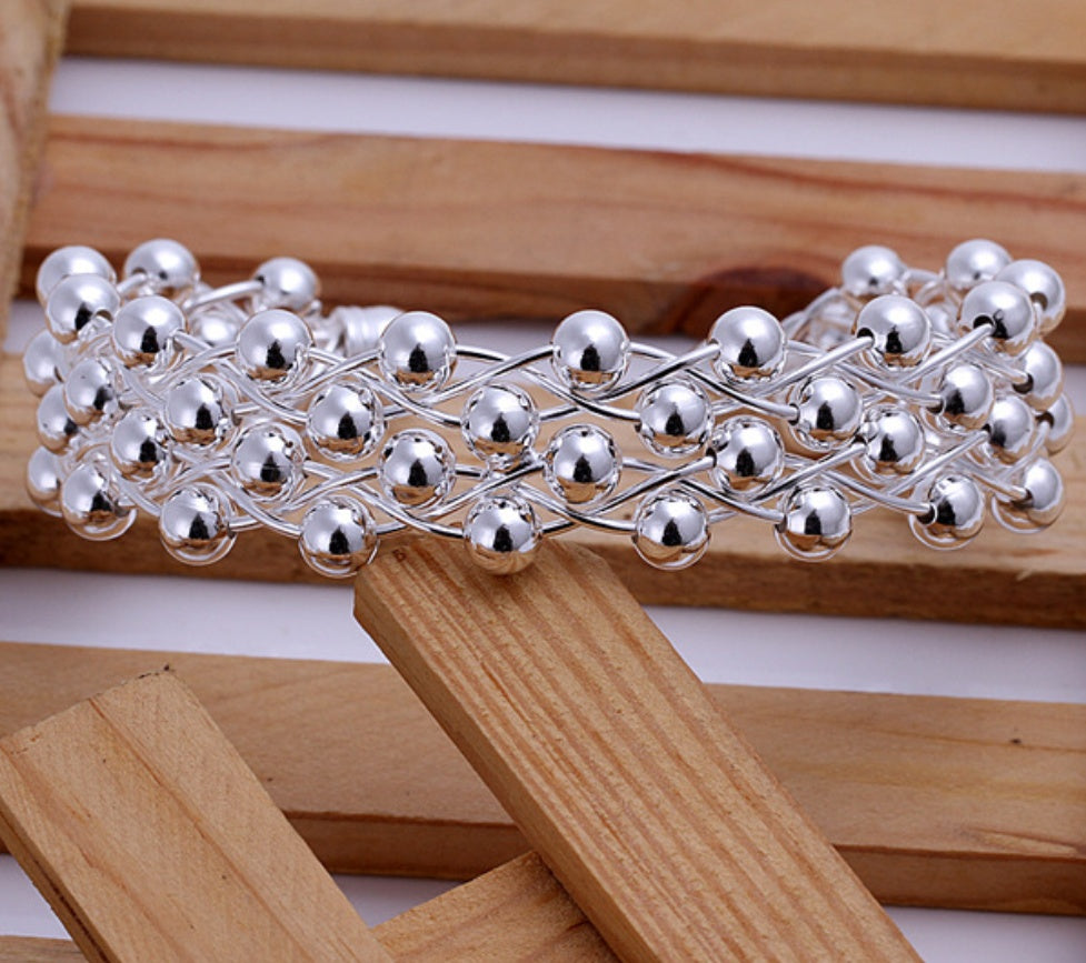 Silver beaded headband on a wooden surface